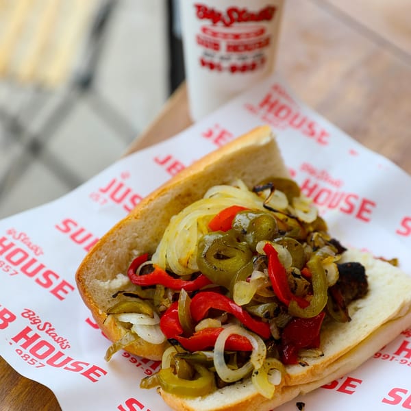 A Big Stash's Sub House deli sandwich filled with grilled onions, red peppers, and jalapeños.
