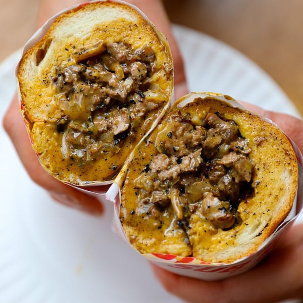 A Big Stash's Sub House cheesesteak, cut in half, revealing melted cheese and steak.